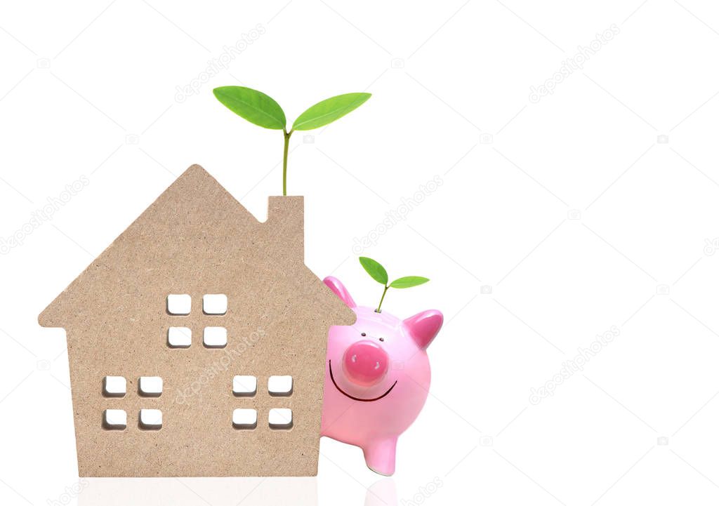 A pink piggy bank and a wooden house with green trees
