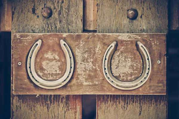 Paard schoenen op houten muur — Stockfoto