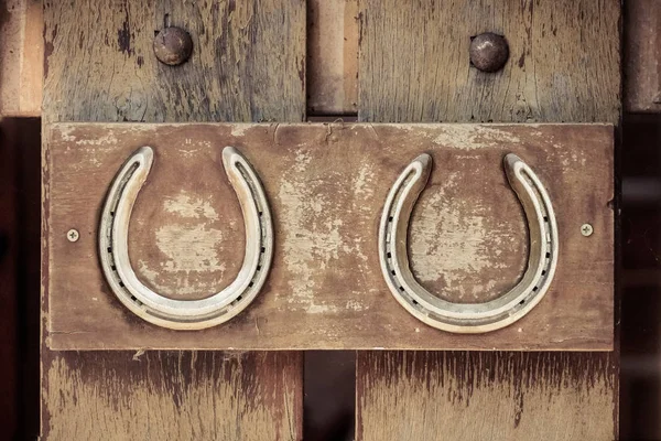 Paard schoenen op houten muur — Stockfoto