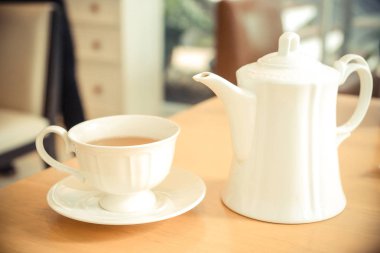 Beyaz fincan çay ve bir sürahi bir tablo