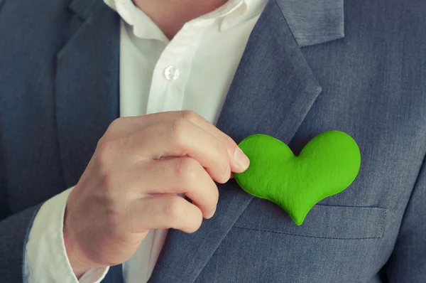 Empresario sosteniendo un corazón verde — Foto de Stock