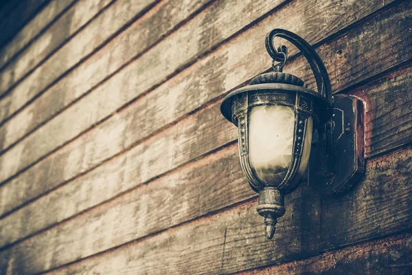 Старая лампа на старой деревянной стене — стоковое фото