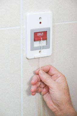Yaşlı hasta tuvalette acil yardım çağrısı kırmızı anahtar çekerek