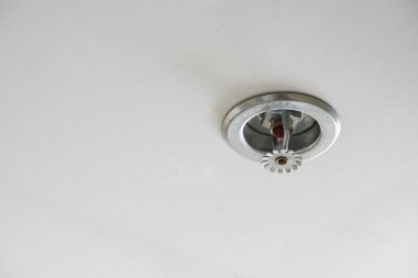 Yangın dedektörü ve arka plan olarak gri tavan ile söndürme
