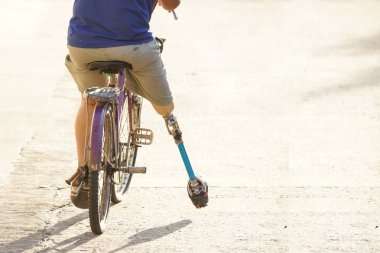 Amputee on a bicycle with copy space to add text clipart