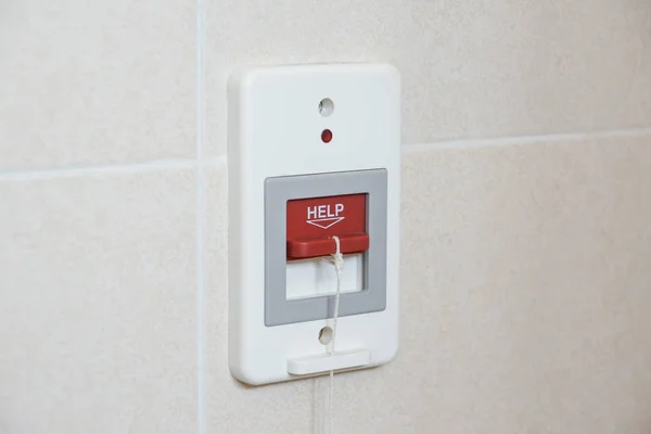 A red switch calling for emergency help in the toilet