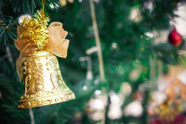 Altın çan asılı Noel ağacına / Merry Christmas