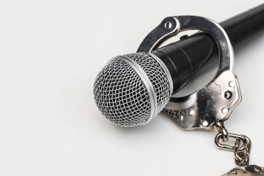 Bir mikrofon ile kelepçe / basın özgürlüğü risk kavramı - dünya basın özgürlüğü günü kavramı