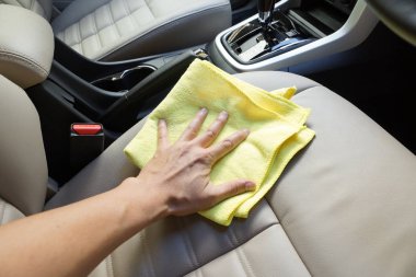 El bir araba içini temizlemek için bir mikrofiber bez kullanarak