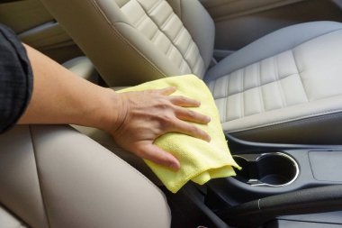 El bir araba içini temizlemek için bir mikrofiber bez kullanarak