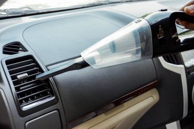 Elektrikli süpürge kullanarak araba temizlemek.