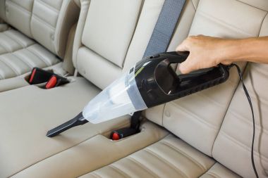 Elektrikli süpürge kullanarak araba temizlemek.