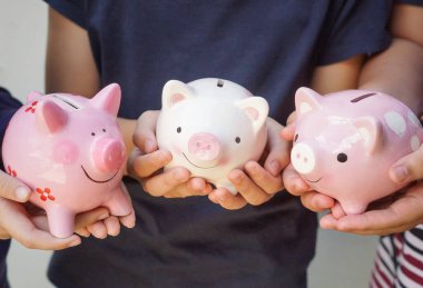 Saving money - Three kids holding piggy banks clipart