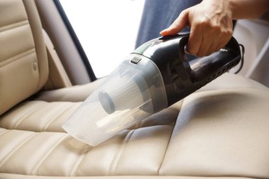 Elektrikli süpürge kullanarak araba temizlemek.