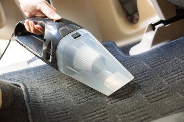 Elektrikli süpürge kullanarak araba temizlemek.