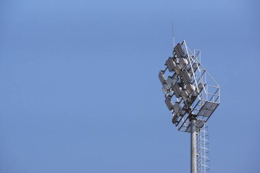 Mavi gökyüzü arkaplanlı bir stadyum ışıkları                                
