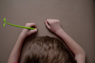 Açık yeşil kalemle çocuk elleri yazmak kağıt üzerinde filizlenir. Yukarıdan görüntüle