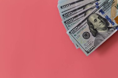 Pembe arka planda dolarların yakın plan çekimi. Yatırım kar geliri. Başarı konsepti. Finans yatırım konsepti. Düz tasarım elemanı. Dolar işareti. Yüz dolarlık banknot.. 
