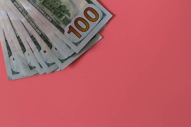 Pembe arka planda dolarların yakın plan çekimi. Yatırım kar geliri. Başarı konsepti. Finans yatırım konsepti. Düz tasarım elemanı. Dolar işareti. Yüz dolarlık banknot.. 