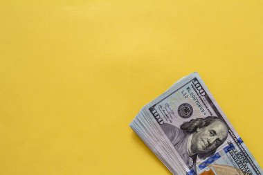 Sarı arka planda dolarların yakın plan çekimi. Yatırım kar geliri. Başarı konsepti. Finans yatırım konsepti. Düz tasarım elemanı. Dolar işareti. Yüz dolarlık banknot..