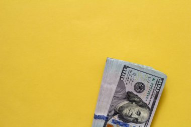 Sarı arka planda dolarların yakın plan çekimi. Yatırım kar geliri. Başarı konsepti. Finans yatırım konsepti. Düz tasarım elemanı. Dolar işareti. Yüz dolarlık banknot..