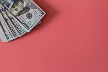Pembe arka planda dolarların yakın plan çekimi. Yatırım kar geliri. Başarı konsepti. Finans yatırım konsepti. Düz tasarım elemanı. Dolar işareti. Yüz dolarlık banknot.. 