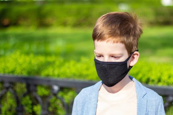 Saddens kid boy wearing black protective mask outdoor. During pandemic covid-19. Antivirus prevention. — Stock Photo, Image