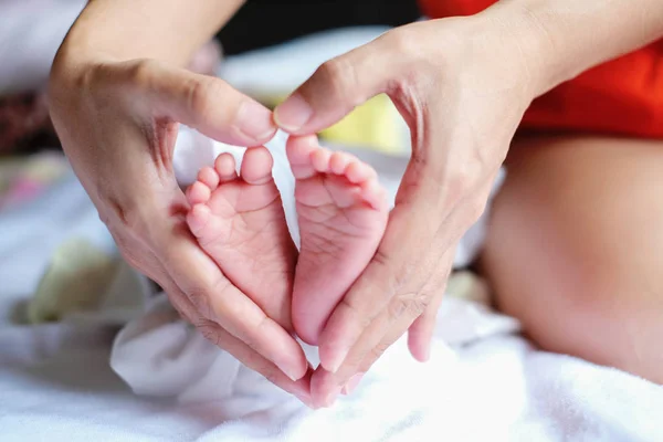 Padres sosteniendo en las manos los pies del bebé recién nacido. — Foto de Stock