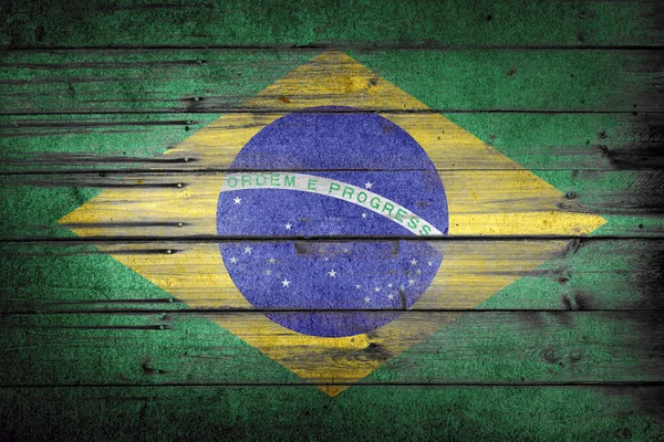 Brazilian rustic, vintage and weathered flag painted on wooden wall. Ordem e progresso text and faded colors. Patriotic and national flag concept.