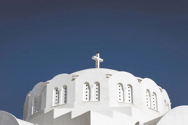 Church in the city of Thira in Santorini. Blue sky, crow, cross, religion, catholic, orthodox, building, travel concept.