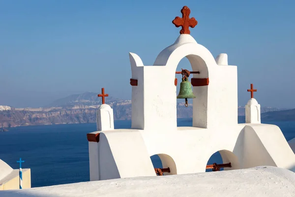 Church with red cross on the island of Thirasia overlooking Oia and Thira in Santorini, Greece. Church, religion, travel, view, summer, holiday concept.