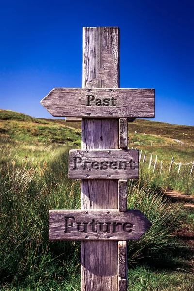 Wooden signpost with carved letters. Future, present, past. Life, sign, signpost, quote, message, texture, guideline, direction concept.