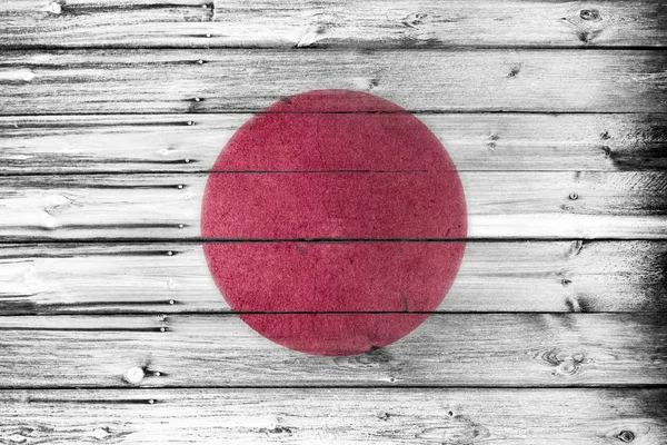 The japanese flag painted and weathered on rustic wooden board wall. National flags and summer olympics 2020 concept.