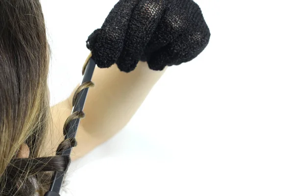 Termal eldivenli bir kadın saçını saç maşasıyla kıvırtır. — Stok fotoğraf