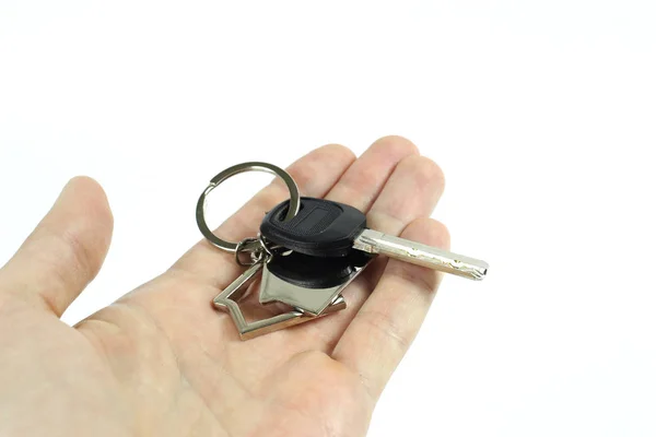 En man håller nycklarna till ett nytt hus i handen. Isolerad på vit bakgrund — Stockfoto