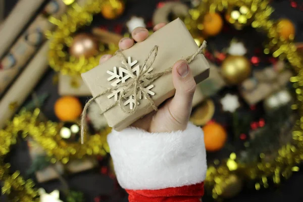 Père Noël tient un cadeau emballé de Noël, mains gros plan — Photo