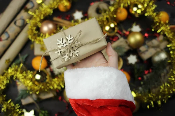 Babbo Natale tiene un regalo di Natale avvolto, mani primo piano — Foto Stock