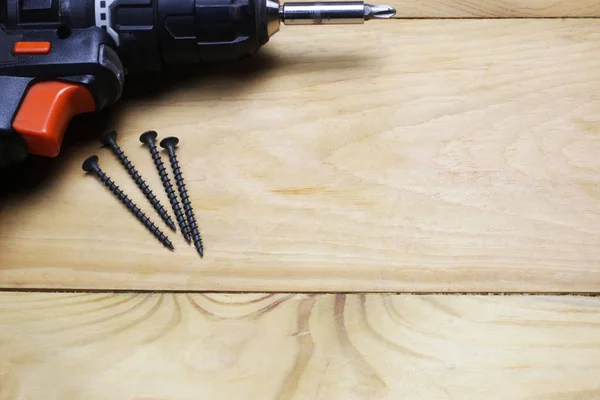 Drill and screws on wooden background — 스톡 사진