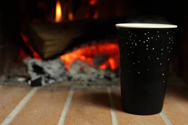 Una tazza di caffè caldo vicino al camino — Foto Stock