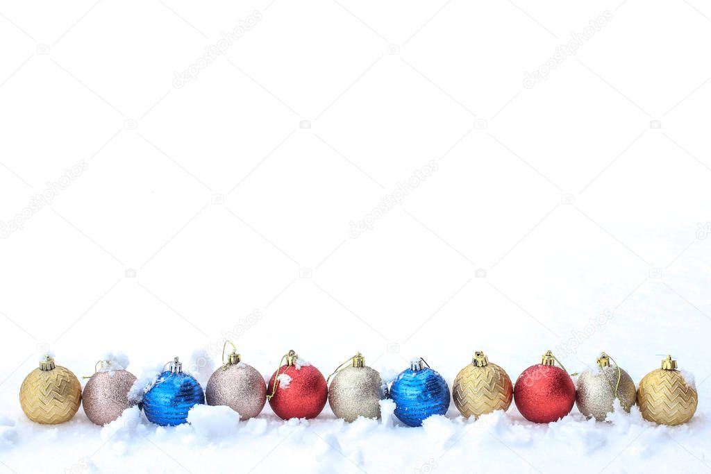 Coloted christmas balls in row isolated on snow, decoration