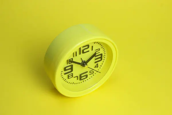 Relógio de alarme amarelo no fundo amarelo — Fotografia de Stock
