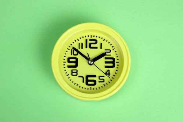 Yellow alarm clock on green background — 스톡 사진