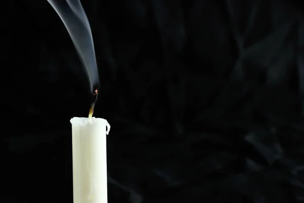 Una vela extinta con humo sobre un fondo negro. copiar espacio para su texto — Foto de Stock