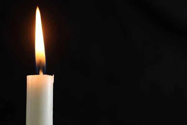 Płonąca świeca na czarnym tle. kopiuj miejsce na tekst — Zdjęcie stockowe