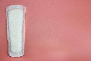 Pembe üzerine hijyenik ped. Kadın kişisel hijyen kavramı. Kritik günler, kan periyodu, adet döngüsü. metin için yer