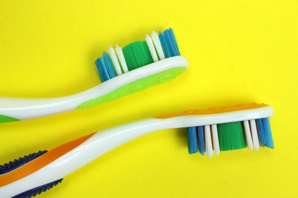 Two toothbrushes on a yellow background — Stock Photo, Image