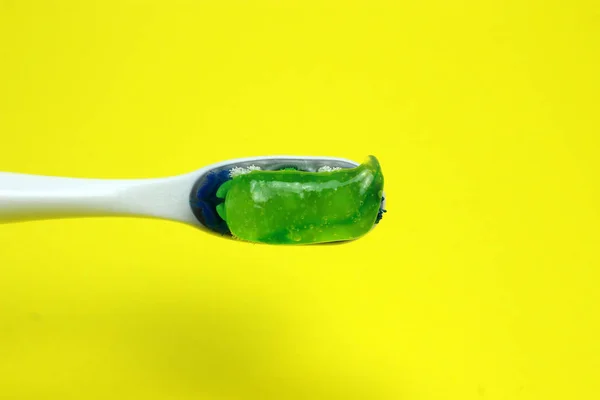 Cepillo de dientes con pasta sobre fondo amarillo — Foto de Stock