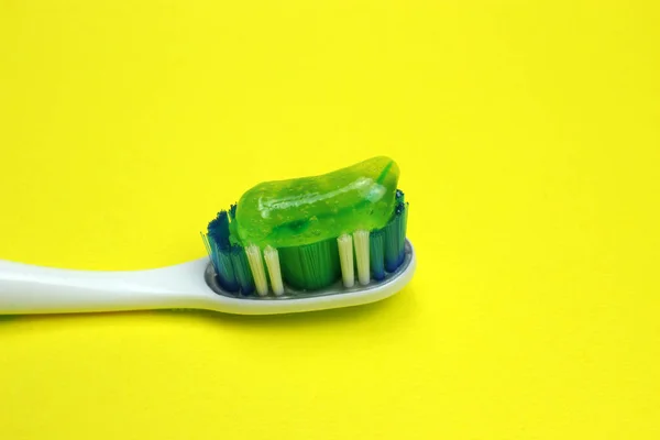 Toothbrush with paste on a yellow background close-up — Stock Photo, Image