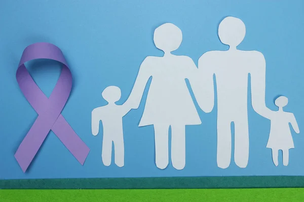 Rodina střižená z papíru a fialové stuhy pro zvýšení povědomí o Alzheimerově chorobě. — Stock fotografie