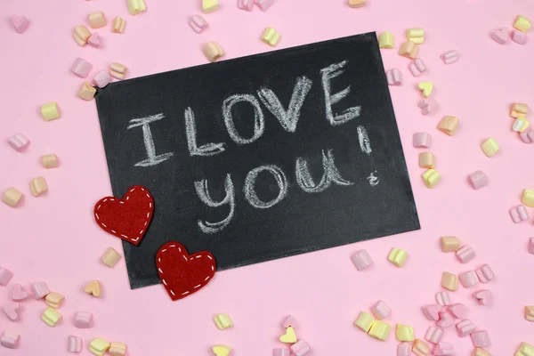 Marshmallow hearts on a pink background. The inscription I love you in chalk on the Board. The view from the top — Stock Photo, Image